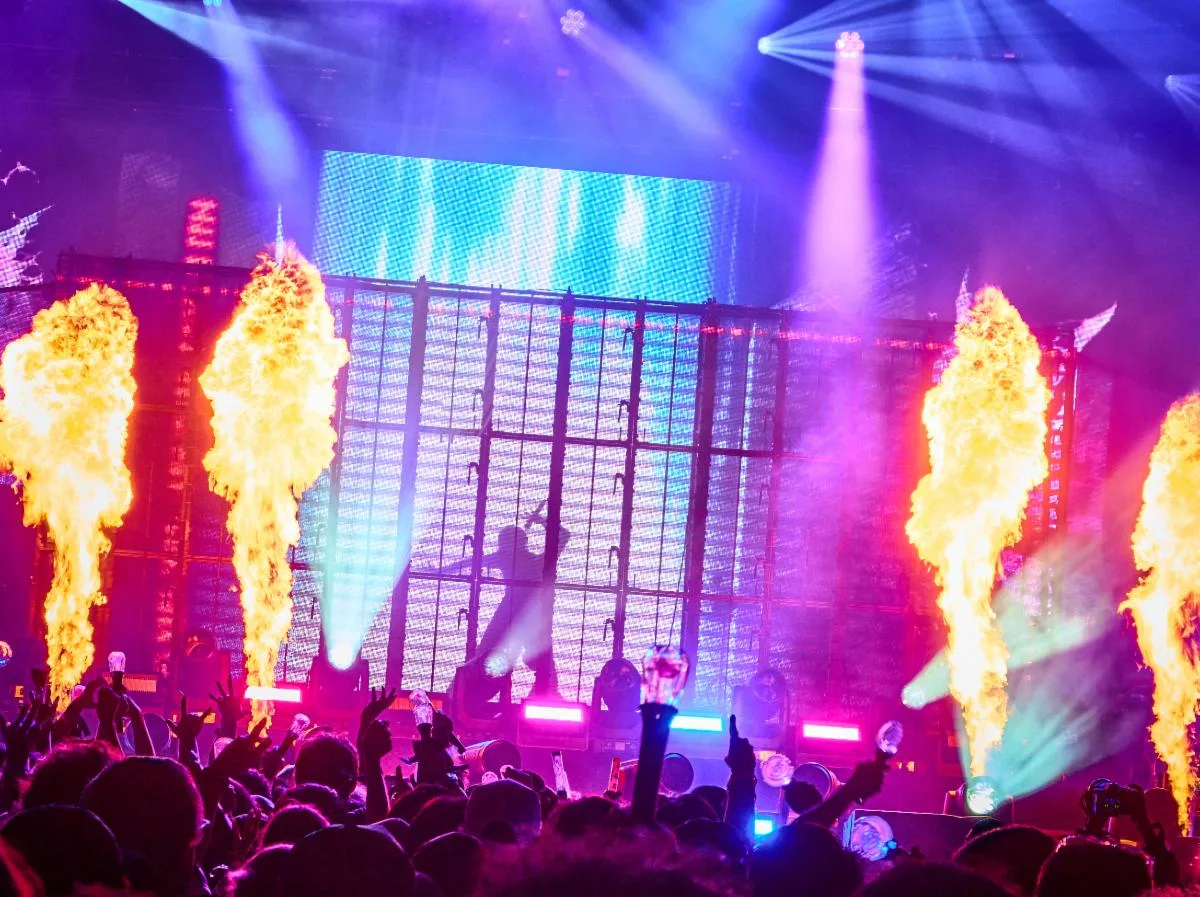 La silueta de Ado dentro de una gran jaula iluminada, entre columnas de fuego, durante su presentación en Lollapalooza Chicago 2026