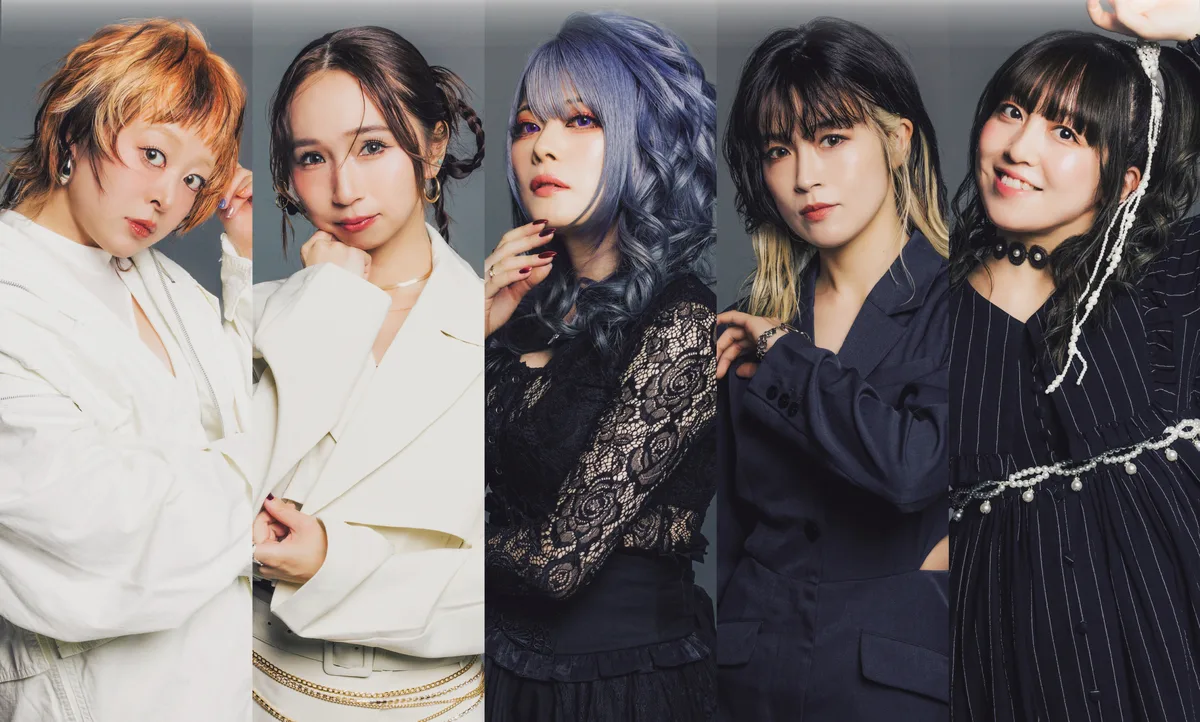 Foto promocional de DOLL$BOXX: las cinco integrantes en fila, dos de blanco a la izquierda, la vocalista de cabello azul al centro y dos de azul marino a la derecha, sobre fondo gris