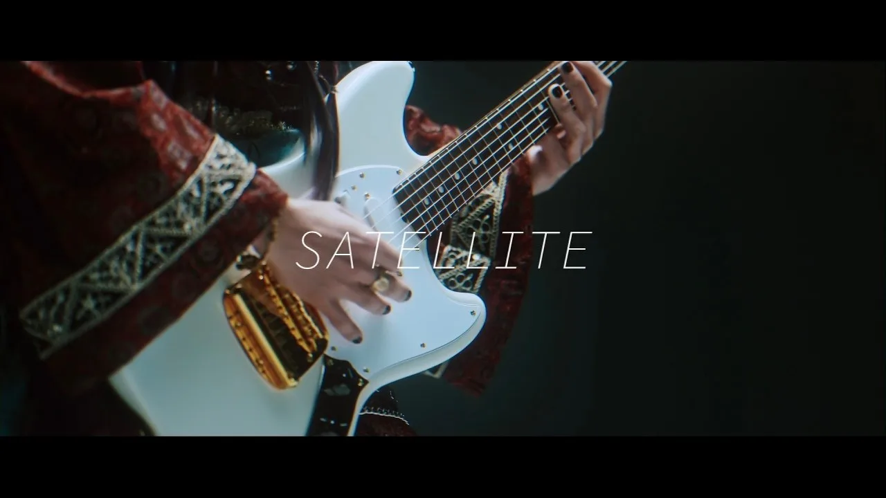 Fotograma del video de SATELLITE de ELISE: un guitarrista toca una guitarra blanca